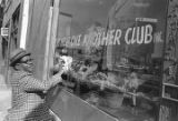 Joe Moore cleaning the front window of The Help One Another Club Inc. on 4th Avenue North near the intersection with 17th Street in downtown Birmingham, Alabama.