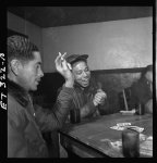 [Tuskegee airmen playing cards in the officers' club in the evening]