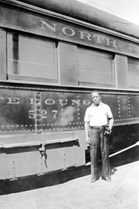 African-American man standing by a train