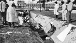 Haitian women washing their clothes in a ditch