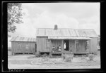 [Untitled photo, possibly related to: House of Negro tenant family. This is a larger house than usual box type. Has several rooms, unscreened, but well kept. Part of the family is sitting on the porch resting--Saturday afternoon. The oldest son on the mule is on his way to visit a neighbor. Pittsboro, North Carolina]