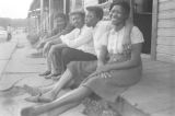 Men and women sitting on the porch in front of a small clapboard house in Little Korea, a neighborhood in Birmingham, Alabama.