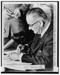 President Johnson is shown as he signed the Civil Rights bill into law during a ceremony in the East Room of the White House