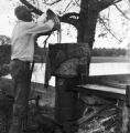 Man filtering sugar cane juice to fill an evaporator pan at a syrup boil in Boyd, Alabama.