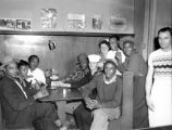 African-American and white patrons sharing cigarettes and a laugh at a local bar, probably Seattle, 1952