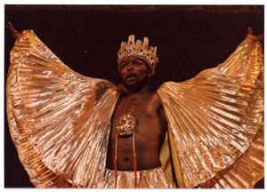 Performance picture of a man in gold wearing a gold crown]. [color photoprint