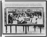 [Billboard with photograph of Dr. Martin Luther King and others seated in a classroom at the Highlander Folk School, Monteagle, Tenn.; caption reads: Martin Luther King at Communist Training School]