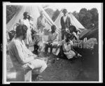 [African Americans in front of tents, with woman working on girl's hair, during a Mississippi River flood, Vicksburg National Military Park]