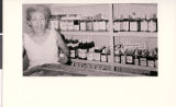 Photograph of "Mrs. Bruno" tending Bruno's Liquor Store