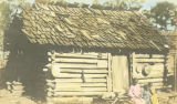 Three African American children in front of a cabin in Wilcox County, Alabama.