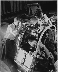 "Final assembly of the pilot's compartment is being made by these Negro workers in a large eastern aircraft factory. These youths went directly from a war training course to their jobs in this plant."