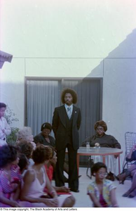 Photograph of Curtis King standing and looking down towards the crowd