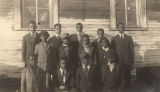 Group of male African American students and teachers gathered outside a rural school building in Evergreen, Alabama.