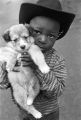 Little boy holding up a puppy while standing in the street in a neighborhood in Montgomery, Alabama.