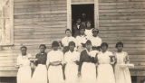 Young African American women holding up baked goods.