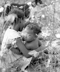 African American child with baby in cotton field