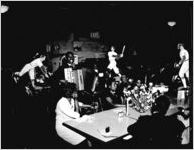 Davison-Paxon Company office party for African-American employees. In this photo, an African-American accordion player is entertaining a group of employees seated at a table. Atlanta, Georgia, April 22, 1947