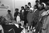 Children in the group "Buds of Promise" from Mt. Zion AME Zion Church in Montgomery, Alabama, singing to an elderly woman in her home.