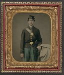 [Unidentified young soldier in Union uniform next to chair draped with overcoat]