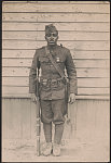 [Unidentified African American soldier in uniform and overseas cap with rifle and knife hanging from cartridge belt]