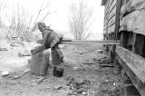 Young daughter of John Nixon lying on wooden planks leading from the back doorway of her home in Autaugaville, Alabama.