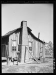 [Untitled photo, possibly related to: Negro cabin, showing grass and mud chimney and broom made of corn husks for sweeping yard. Taylorsville, Mississippi]