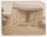 Two African American women and baby on porch of river dwelling