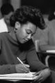 A student takes notes during a class lecture, 1989