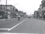 Man crosses street after riot, Rochester, NY, 1964