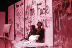 Thumbnail for Play performance: two actors or dancers sitting against graffiti backdrop