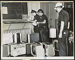 Police at Gates Ave. station in Brooklyn check loot, including several portable television sets, that had been confiscated from rioters