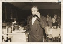 Mississippi State Sovereignty Commission photograph of Mr. Helm dressed in a tuxedo and talking on a telephone while at work as the head waiter at Edwards Hotel in Jackson, Mississippi, 1950s