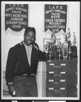 Member of LAPD Deputy Auxiliary Police football team with trophy, circa 1946, Los Angeles