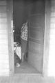 Person standing at the door of a small clapboard house in Little Korea, a neighborhood in Birmingham, Alabama.