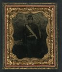 [Unidentified soldier in Union uniform with bayoneted musket in front of painted backdrop showing trees]