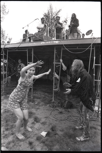 May Day concert and demonstrations: couple dancing below concert stage while Charles Mingus performs