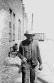 Jasper Wood Collection: Man with bottle standing on sidewalk