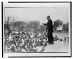 [Booker T. Washington on outdoor stage speaking to school children in [...]tsonville]