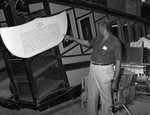 Jesse Peters reading a sign on an Angels' Flight car in storage, Los Angeles, 1983