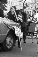 Man leaning against a car during a Ku Klux Klan rally in Montgomery, Alabama.