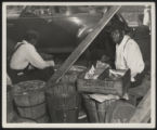 Assembly Street, man eating watermelon at stall under shed, 1946