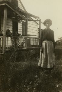 Gullah woman standing in front of her house