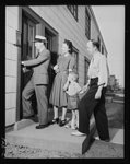 Defense housing, Erie, Pennsylvania. J.P. Kane, local defense housing manager, gives B.J. Rogan and his family a preview of their new home. 56 of the 300 defense homes now under construction in Erie, Pennsylvania had been completed when these pictures were made (July 1941). The others were scheduled for occupancy by the first of October 1941. There are four units to a building, each with a combination living-dining room, kitchen, bath, and one to three bedrooms, depending on the size of the family