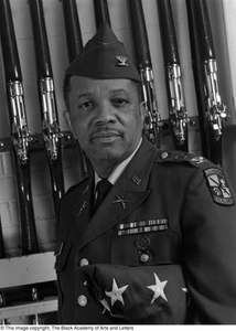 Colonel Joe D. Sasser posing with drill rifles