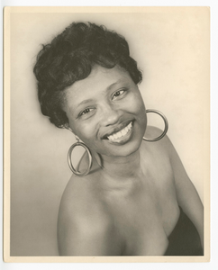 Photographic print of a woman wearing large hoop earrings and a black drape