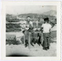 Brock strums guitar at Hook base camp with Le Bon Duc and Borders