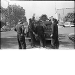Firemen loading fire hose onto fire truck