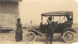 Mary Thomas speaking to a man standing next to an automobile.