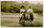 Two women riding donkeys