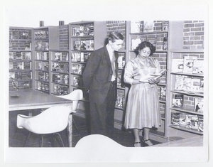 Photograph of Mildred L. Terry showing John R. Bannister a book in the Fourth Avenue Library, Columbus, Georgia